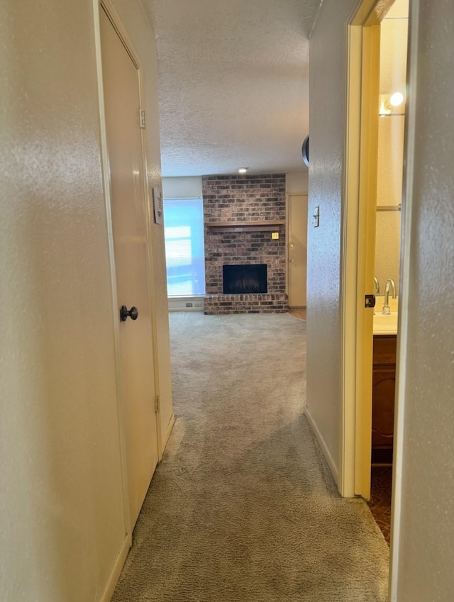 13424 Castilian Dr Unit 113, Houston, TX 77015 - hall with carpet floors, a textured ceiling, and a sink