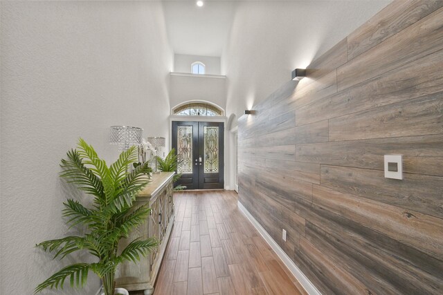 9223 Holloway Cliff Ln, Cypress, TX 77433 - doorway featuring wood walls, french doors, wood finished floors, and a high ceiling
