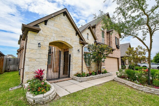 4414 Tilbury Trl, Richmond, TX 77407 - view of front of house with stone siding, a gate, a garage, and driveway