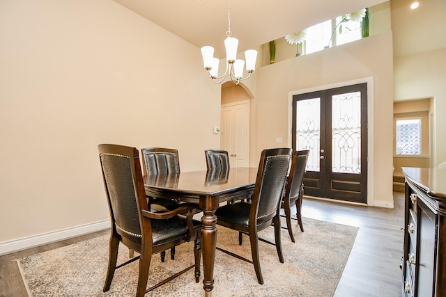 4414 Tilbury Trl, Richmond, TX 77407 - dining area with a chandelier, baseboards, wood finished floors, a high ceiling, and arched walkways