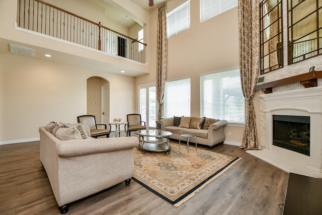 4414 Tilbury Trl, Richmond, TX 77407 - living room with baseboards, healthy amount of natural light, arched walkways, wood finished floors, and a towering ceiling