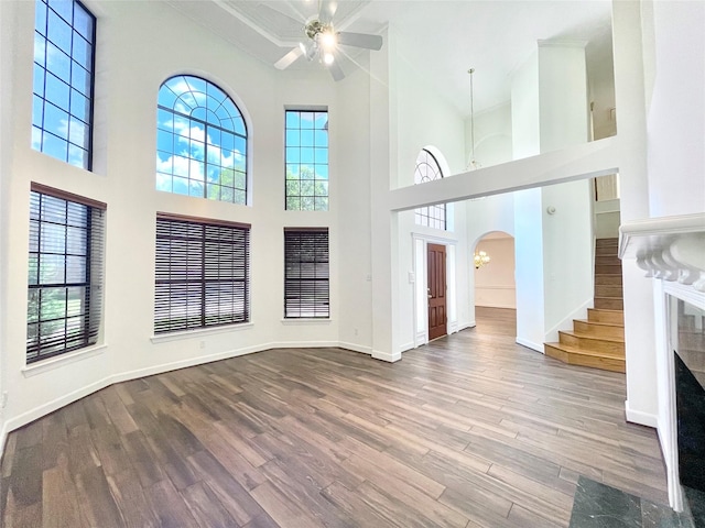 1265 Ridgewood Pl, Houston, TX 77055 - unfurnished living room with arched walkways, wood finished floors, a ceiling fan, plenty of natural light, and a high ceiling
