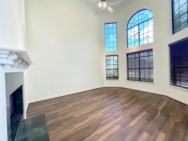 1265 Ridgewood Pl, Houston, TX 77055 - unfurnished living room with a towering ceiling, dark wood-type flooring, plenty of natural light, a ceiling fan, and crown molding