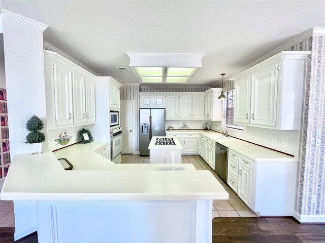 1265 Ridgewood Pl, Houston, TX 77055 - kitchen with stainless steel appliances, a sink, a peninsula, and light countertops