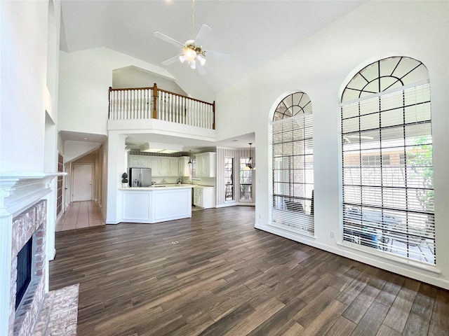 1265 Ridgewood Pl, Houston, TX 77055 - unfurnished living room featuring high vaulted ceiling, ceiling fan, dark wood-style floors, a fireplace, and baseboards