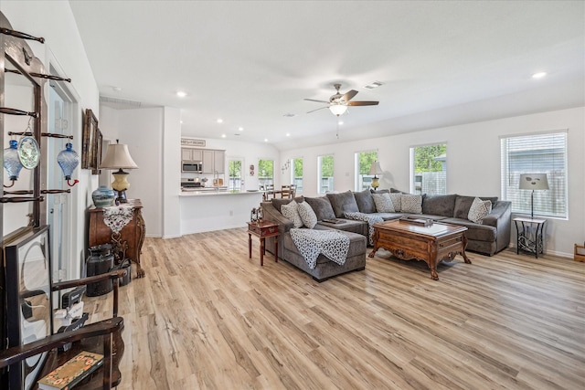 living area with light wood-style flooring, ceiling fan, plenty of natural light, recessed lighting, and baseboards