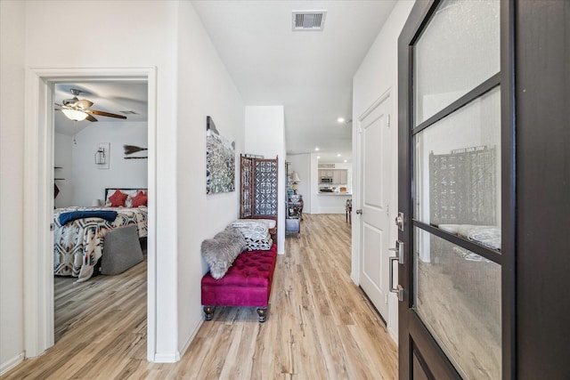 corridor featuring light wood-style flooring and recessed lighting