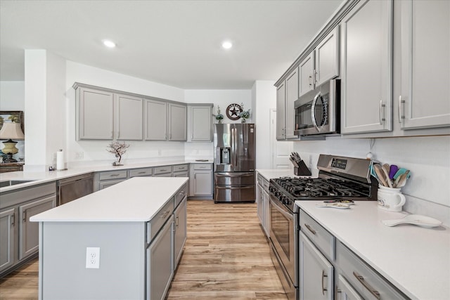 kitchen featuring stainless steel appliances, gray cabinetry, light wood-style flooring, light countertops, and recessed lighting