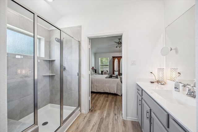 full bathroom featuring connected bathroom, a shower stall, wood finished floors, ceiling fan, and vanity