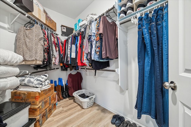 walk in closet with wood finished floors