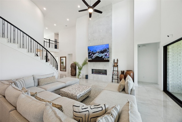 21502 Lowlands Ln, Cypress, TX 77433 - living room with a towering ceiling, ceiling fan, a premium fireplace, stairs, and recessed lighting