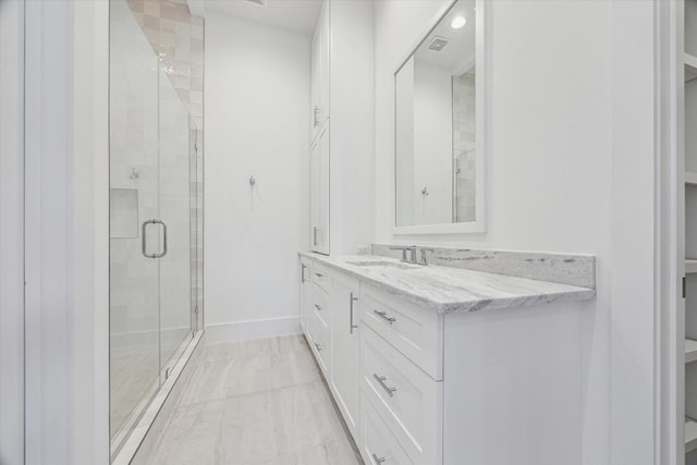 full bathroom featuring a shower stall, vanity, baseboards, and marble finish floors