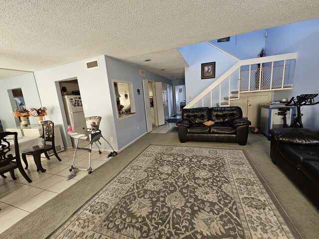 9807 Bent Branch Ln, Dallas, TX 75243 - carpeted living room featuring stairs, a textured ceiling, tile patterned floors, and baseboards