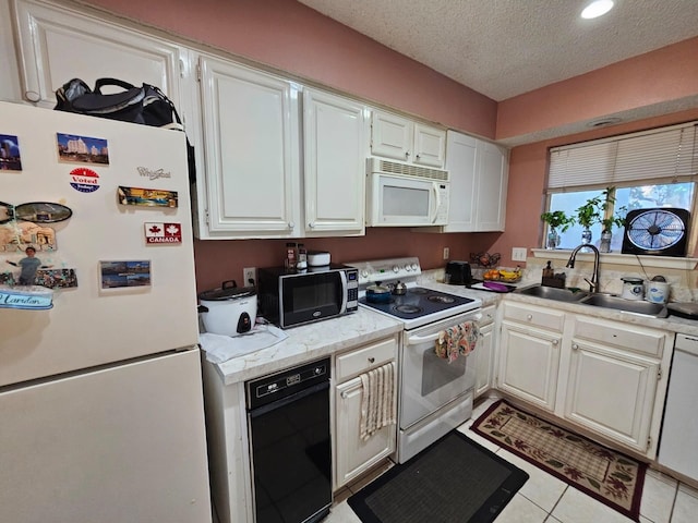 9807 Bent Branch Ln, Dallas, TX 75243 - kitchen featuring white appliances, a sink, white cabinets, a textured ceiling, and light tile patterned floors