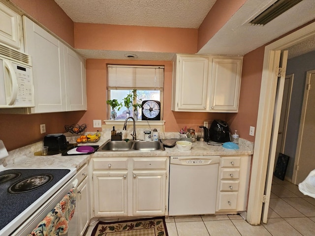 9807 Bent Branch Ln, Dallas, TX 75243 - kitchen featuring white appliances, a sink, light countertops, light tile patterned floors, and a textured ceiling