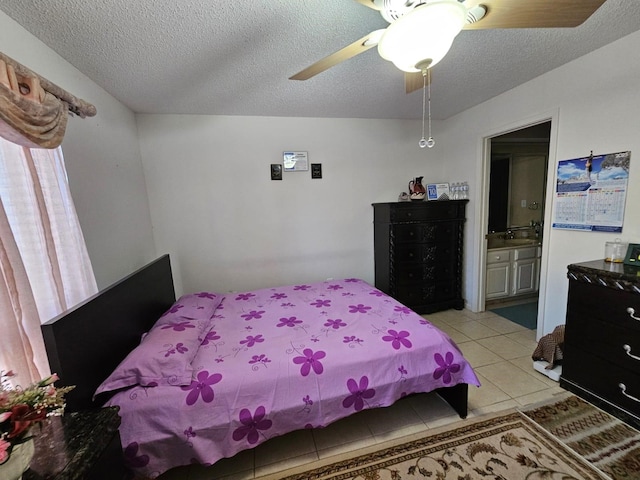 9807 Bent Branch Ln, Dallas, TX 75243 - bedroom featuring a textured ceiling, light tile patterned floors, ensuite bath, a sink, and a ceiling fan