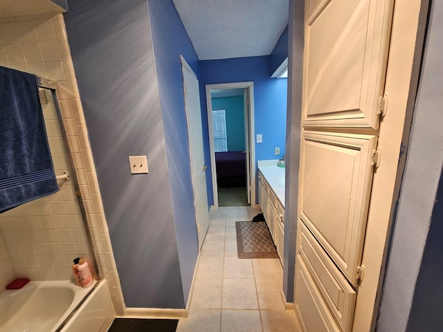 9807 Bent Branch Ln, Dallas, TX 75243 - full bathroom featuring tile patterned flooring, a textured ceiling, vanity, and baseboards
