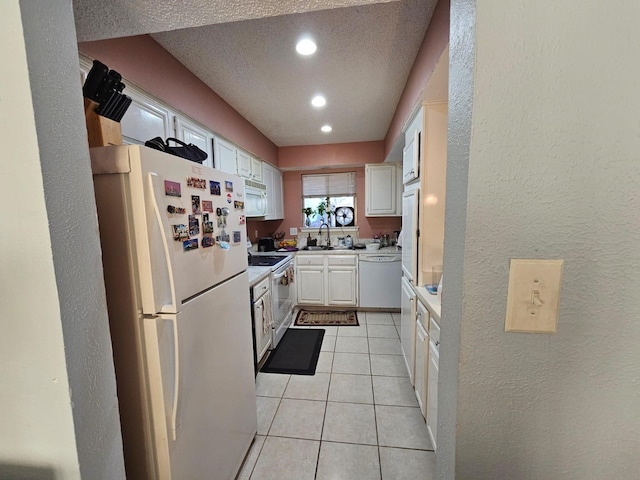 9807 Bent Branch Ln, Dallas, TX 75243 - kitchen with white appliances, a sink, white cabinetry, a textured wall, and light tile patterned floors