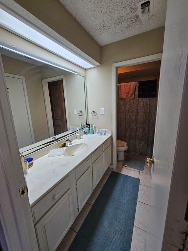9807 Bent Branch Ln, Dallas, TX 75243 - bathroom with toilet, vanity, tile patterned floors, a textured ceiling, and a shower with curtain