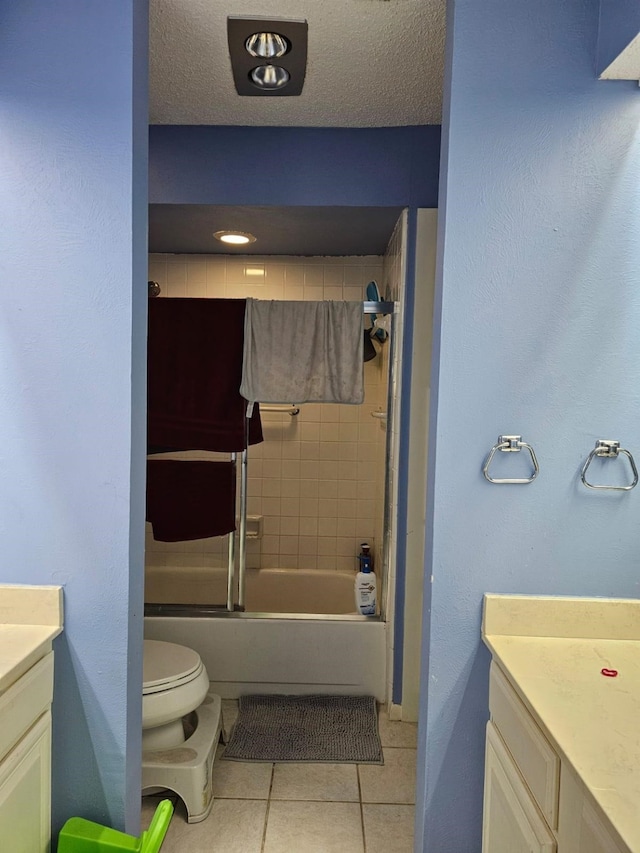 9807 Bent Branch Ln, Dallas, TX 75243 - full bath with tile patterned floors, vanity, toilet, combined bath / shower with glass door, and a textured ceiling