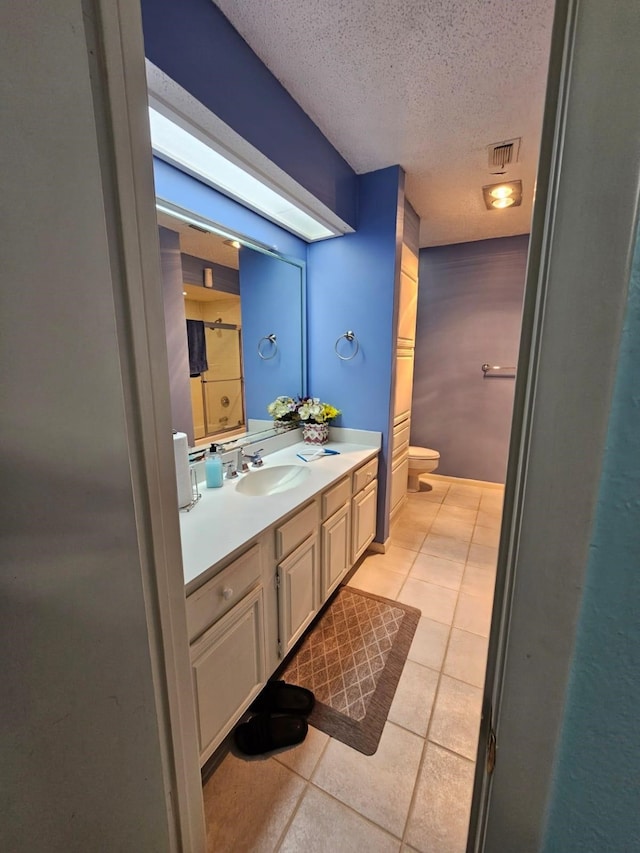 9807 Bent Branch Ln, Dallas, TX 75243 - bathroom with a textured ceiling, toilet, tile patterned flooring, and vanity