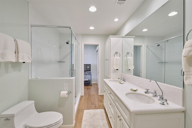 1378 Landing Way, Trinity, TX 75862 - full bath featuring a stall shower, toilet, wood finished floors, recessed lighting, and double vanity