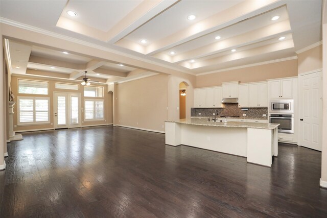 506 Chirping Sparrow Ct, Pinehurst, TX 77362 - kitchen with appliances with stainless steel finishes, arched walkways, ceiling fan, under cabinet range hood, and tasteful backsplash