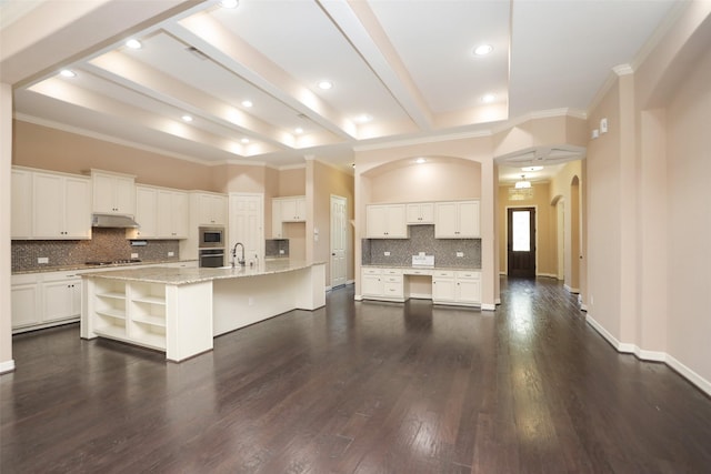 506 Chirping Sparrow Ct, Pinehurst, TX 77362 - kitchen featuring under cabinet range hood, stainless steel appliances, crown molding, tasteful backsplash, and white cabinets