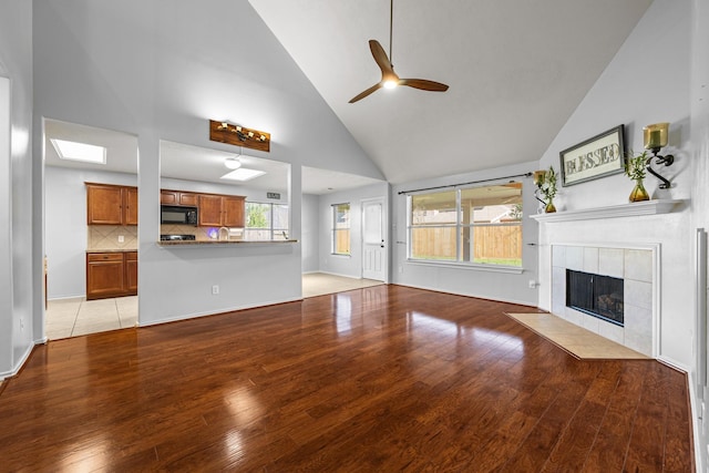 8414 Coriander Ln, Baytown, TX 77521 - unfurnished living room featuring high vaulted ceiling, a ceiling fan, light wood-style floors, a fireplace, and baseboards
