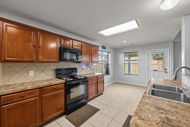 8414 Coriander Ln, Baytown, TX 77521 - kitchen featuring black appliances, a sink, backsplash, a skylight, and light tile patterned floors