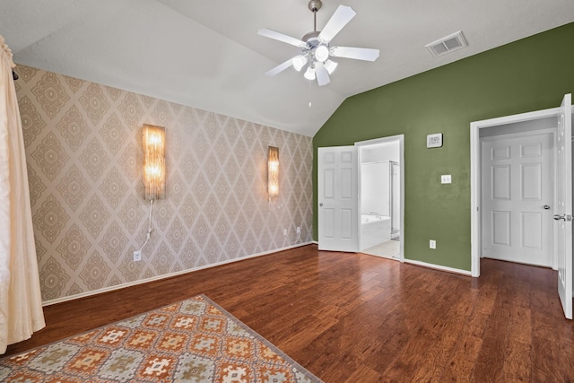 8414 Coriander Ln, Baytown, TX 77521 - unfurnished bedroom featuring wallpapered walls, vaulted ceiling, wood finished floors, baseboards, and ensuite bath