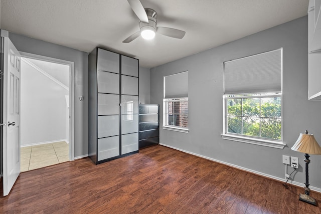 8414 Coriander Ln, Baytown, TX 77521 - unfurnished bedroom with dark wood-style floors, baseboards, and ceiling fan