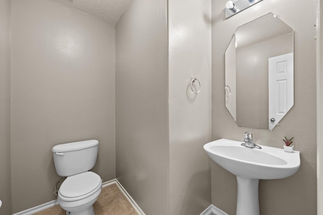 8414 Coriander Ln, Baytown, TX 77521 - bathroom with toilet, tile patterned floors, baseboards, and a textured ceiling
