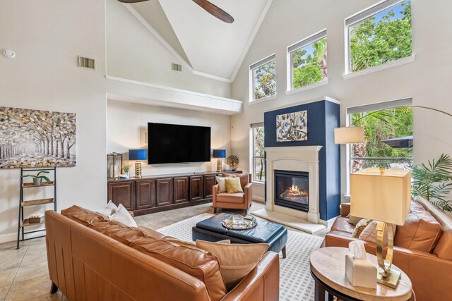 15730 Hunters Lake Way, Houston, TX 77044 - living area featuring high vaulted ceiling, a glass covered fireplace, ceiling fan, baseboards, and light tile patterned flooring