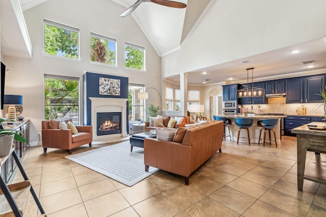 15730 Hunters Lake Way, Houston, TX 77044 - living area featuring a glass covered fireplace, healthy amount of natural light, high vaulted ceiling, ceiling fan, and a chandelier