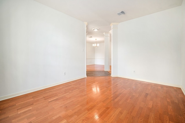 3815 Shadow Knoll Ct, Houston, TX 77082 - unfurnished room featuring a chandelier, light wood finished floors, baseboards, and ornate columns