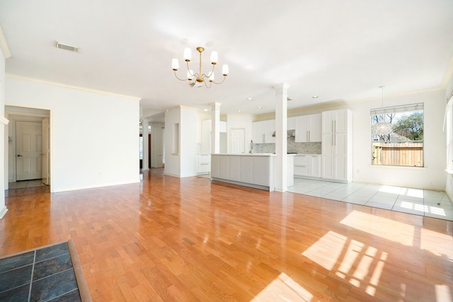 3815 Shadow Knoll Ct, Houston, TX 77082 - unfurnished living room with crown molding, light wood-type flooring, a chandelier, baseboards, and a sink