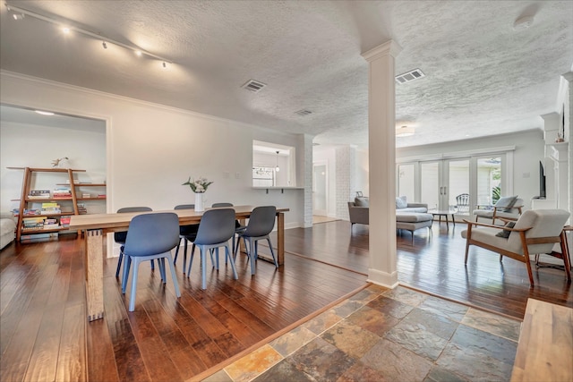 dining area with decorative columns, dark wood-style flooring, ornamental molding, and baseboards