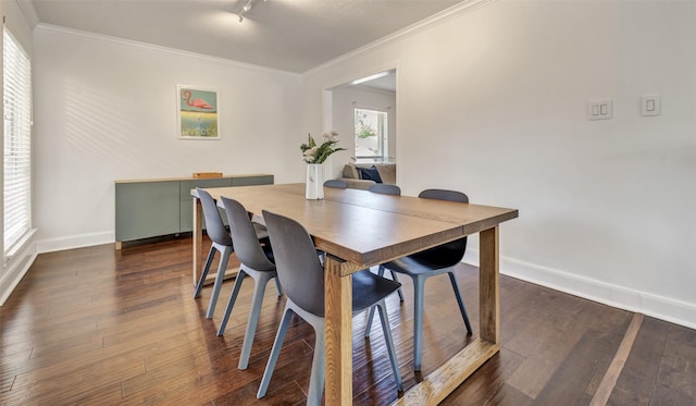 dining room featuring crown molding, baseboards, rail lighting, and dark wood-style flooring