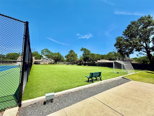 view of community with an area for sports and fence