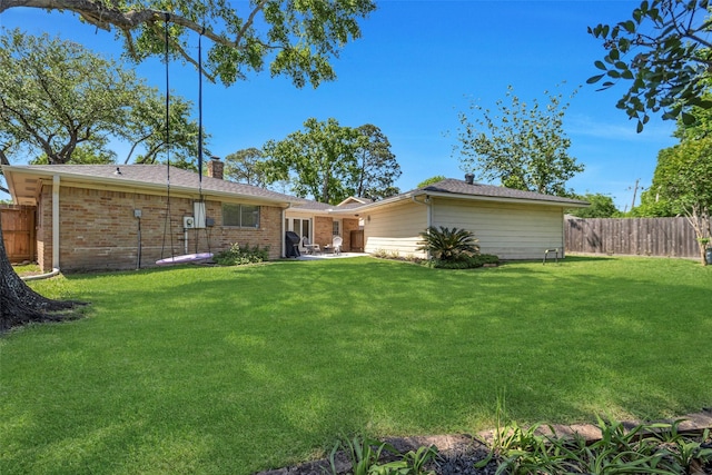 back of property with a chimney, a patio area, and brick siding
