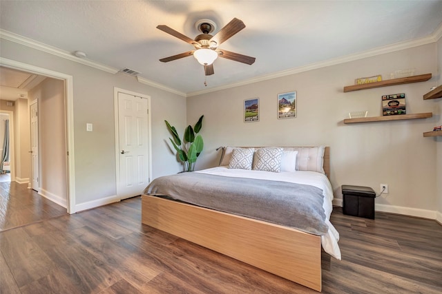 bedroom with wood finished floors, attic access, baseboards, ornamental molding, and a ceiling fan