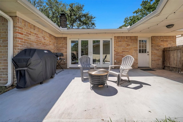 view of patio / terrace featuring grilling area, french doors, and fence