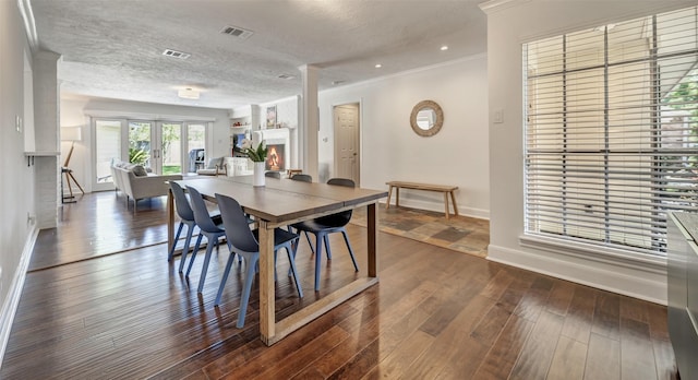 dining space with baseboards, dark wood-style flooring, ornamental molding, a textured ceiling, and recessed lighting