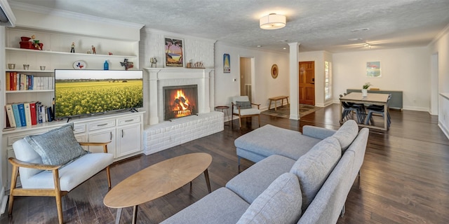 living room featuring crown molding, a textured ceiling, wood finished floors, a fireplace, and baseboards