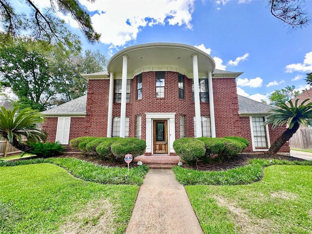 10614 Gold Point Dr, Houston, TX 77064 - neoclassical / greek revival house with brick siding, a front yard, and roof with shingles