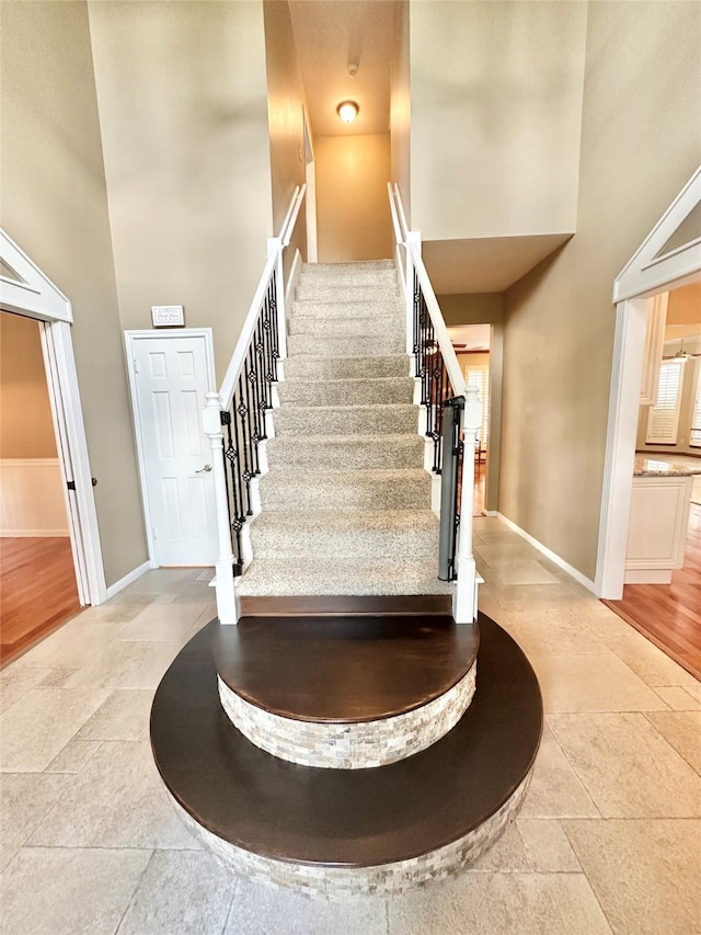 10614 Gold Point Dr, Houston, TX 77064 - staircase featuring a high ceiling, baseboards, and stone finish floors