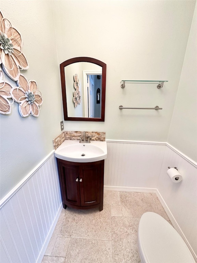 10614 Gold Point Dr, Houston, TX 77064 - half bathroom featuring a wainscoted wall, vanity, and toilet