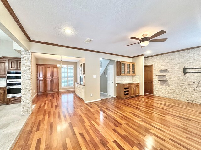 10614 Gold Point Dr, Houston, TX 77064 - unfurnished living room featuring light wood-style flooring, a ceiling fan, a chandelier, a textured ceiling, and ornamental molding