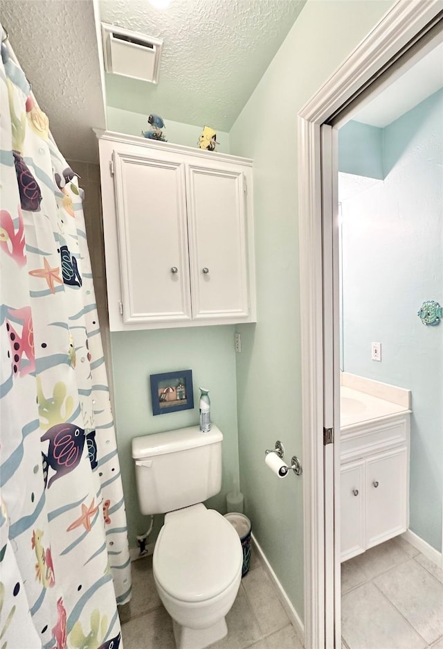 10614 Gold Point Dr, Houston, TX 77064 - bathroom featuring a textured ceiling, tile patterned floors, baseboards, vanity, and toilet